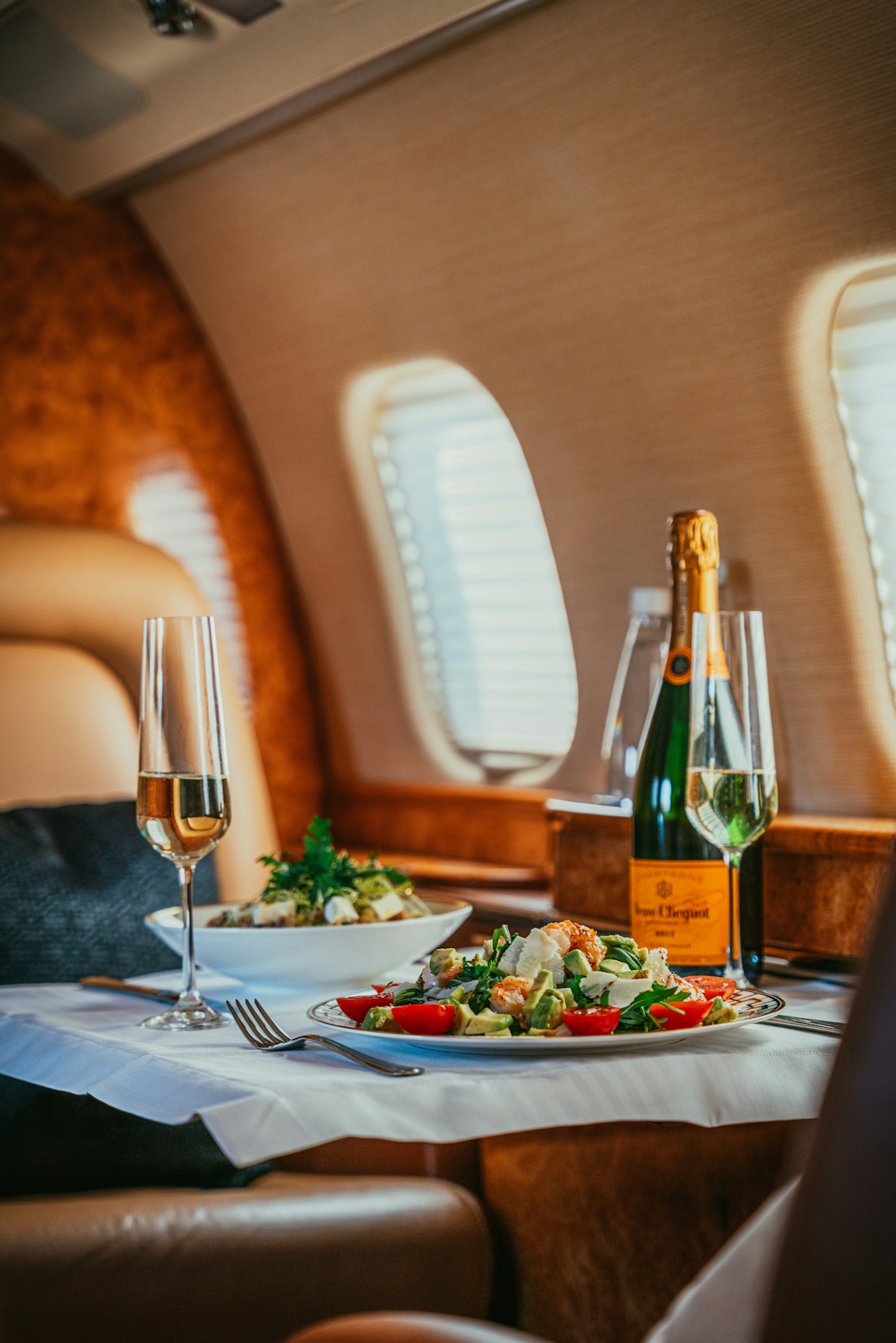 Champagner und feine Speisen an Bord einer Privatjet-Kabine